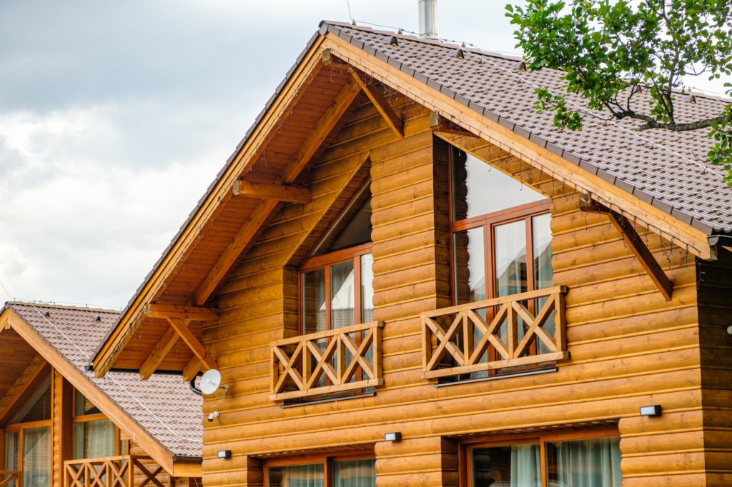 Modern wooden house with big windows and balcony. Concept of building of family houses, pensions or